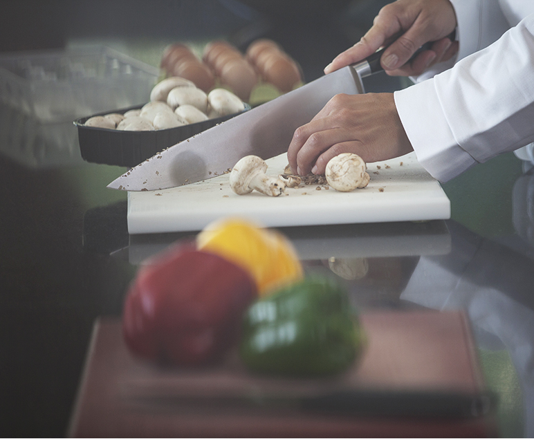 도마 위에서 버섯을 칼로 써는 손