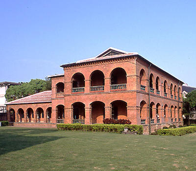 대만 단수이 홍마오청, 붉은 벽돌 아치형 복도를 가진 2층 건물과 잔디 정원
